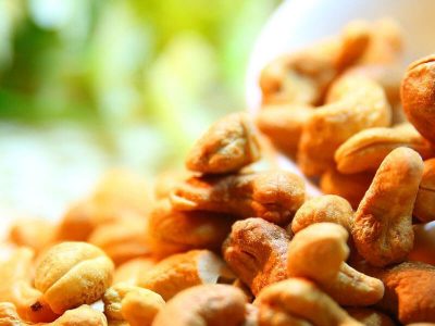 Nüsse mit viel Eiweiß fallen aus einer weißen Schale, Nüsse stärken die Gesundheit, das Immunsystem stärken